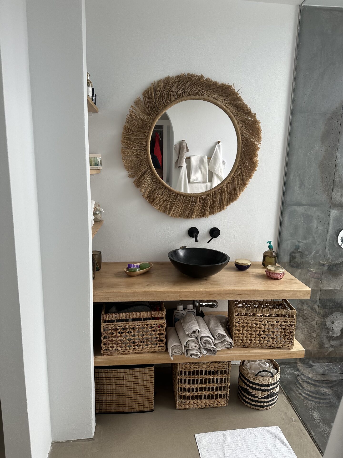 Salle de bain avec miroir en fibres naturelles et vasque noir mat
