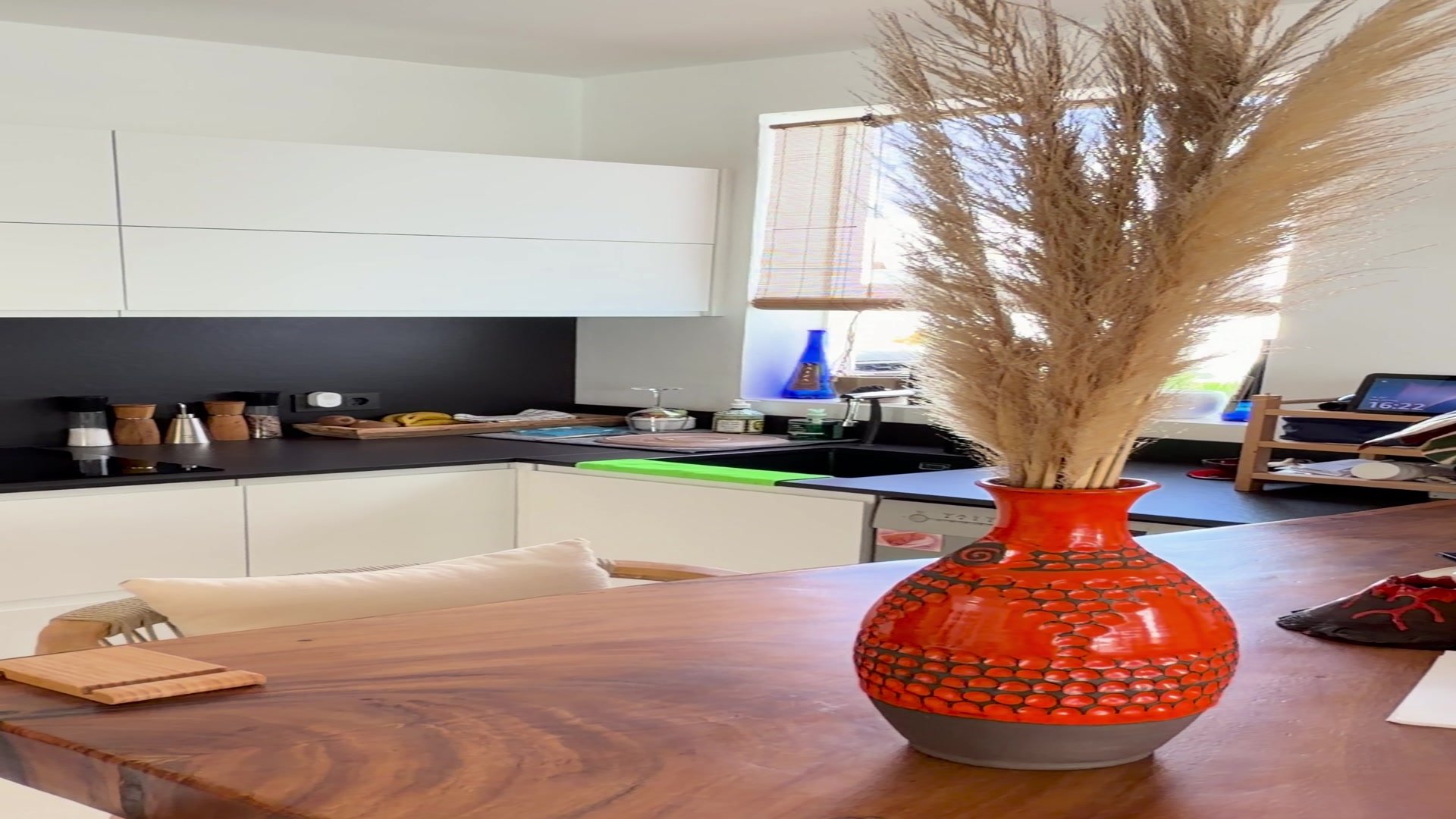 Cuisine principale avec plan de travail blanc en courbe et vase décoratif